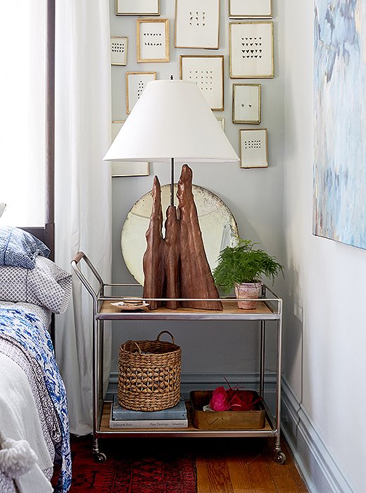Bar carts can sidle into snug spaces even petite nightstands can’t, and they offer easy access to bedside must-haves. Photo by Tony Vu.
